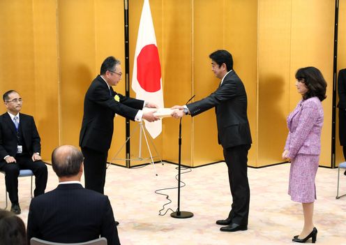 Photograph of the Prime Minister presenting a certificate of award