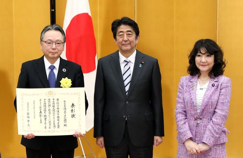 Photograph of the Prime Minister presenting a certificate of award