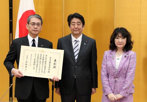 Photograph of the Prime Minister presenting a certificate of award