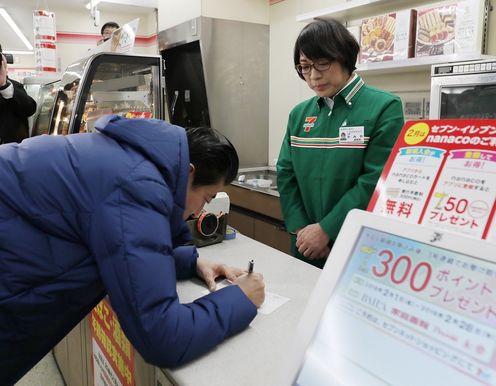 Photograph of the Prime Minister applying for a prepaid electronic money card