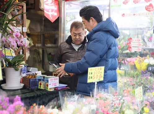 Photograph of the Prime Minister making a purchase using the QR code payment system