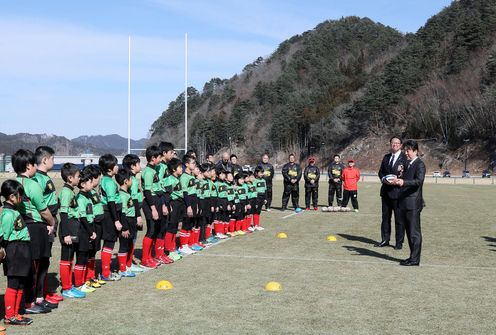 Photograph of the Prime Minister observing children practicing rugby