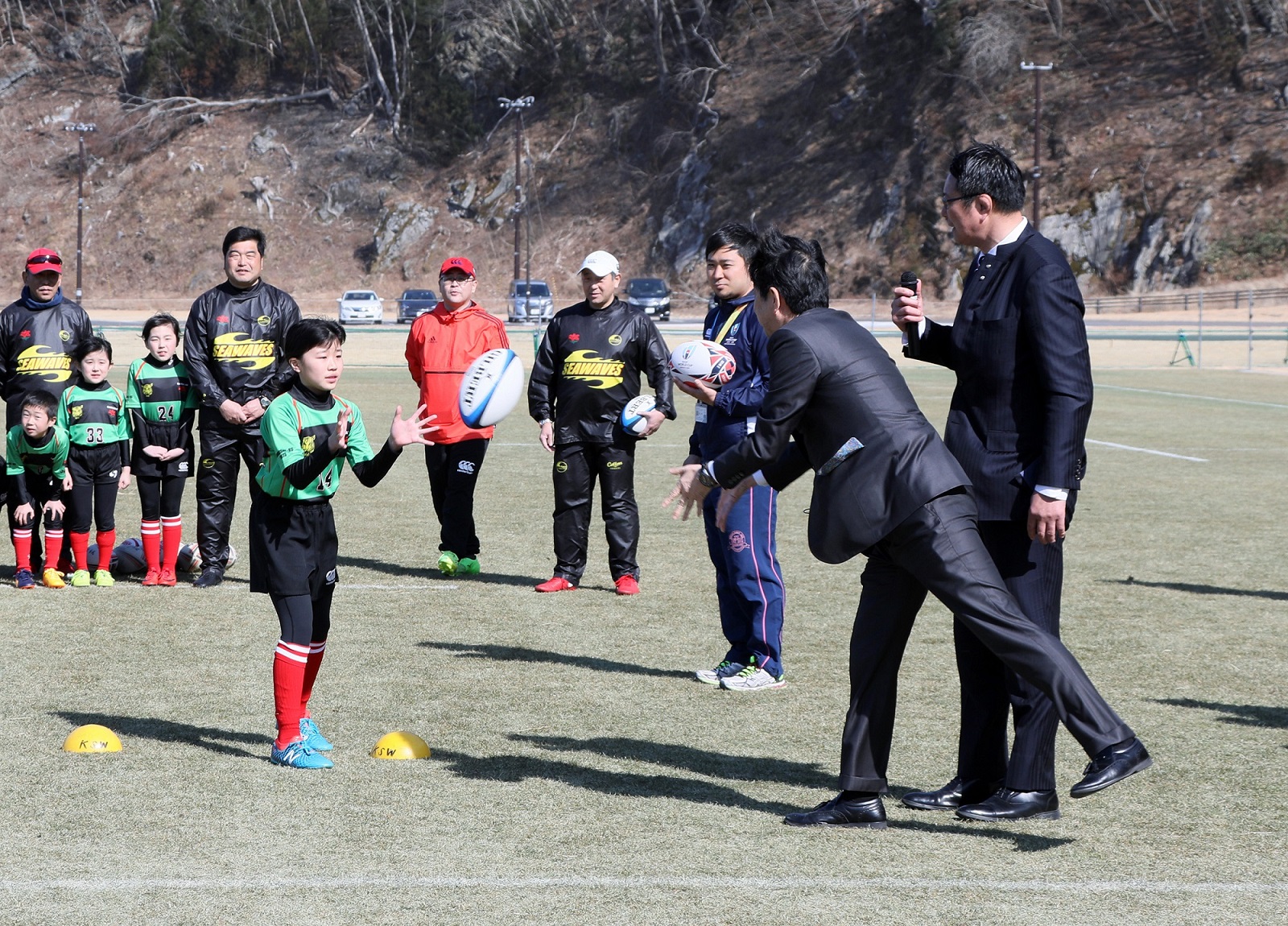 Photograph of the Prime Minister observing children practicing rugby