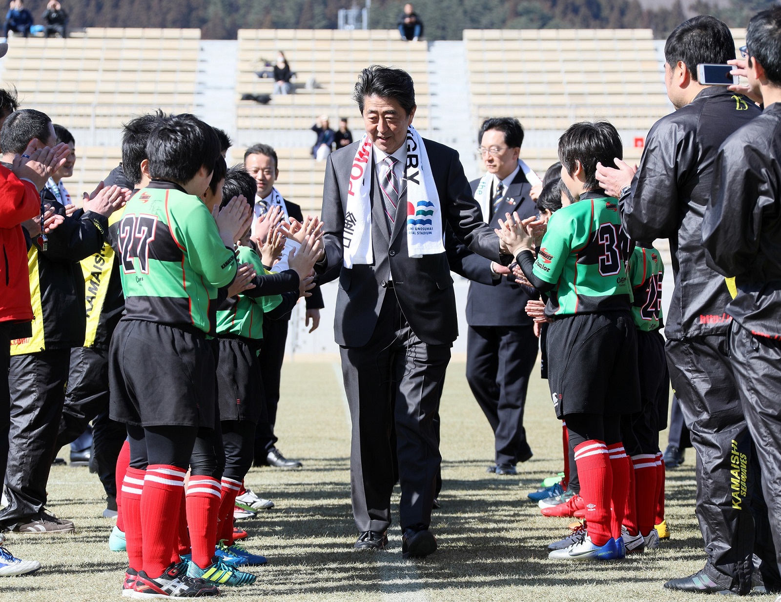 Photograph of the Prime Minister observing children practicing rugby