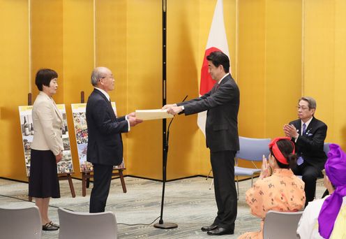 Photograph of the Prime Minister presenting a certificate of award