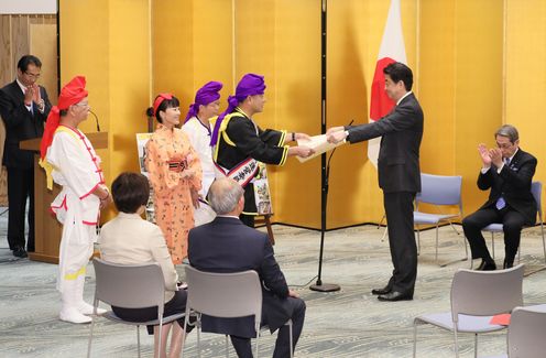 Photograph of the Prime Minister presenting a certificate of award