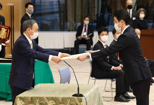 Photograph of the Prime Minister presenting a certificate of award