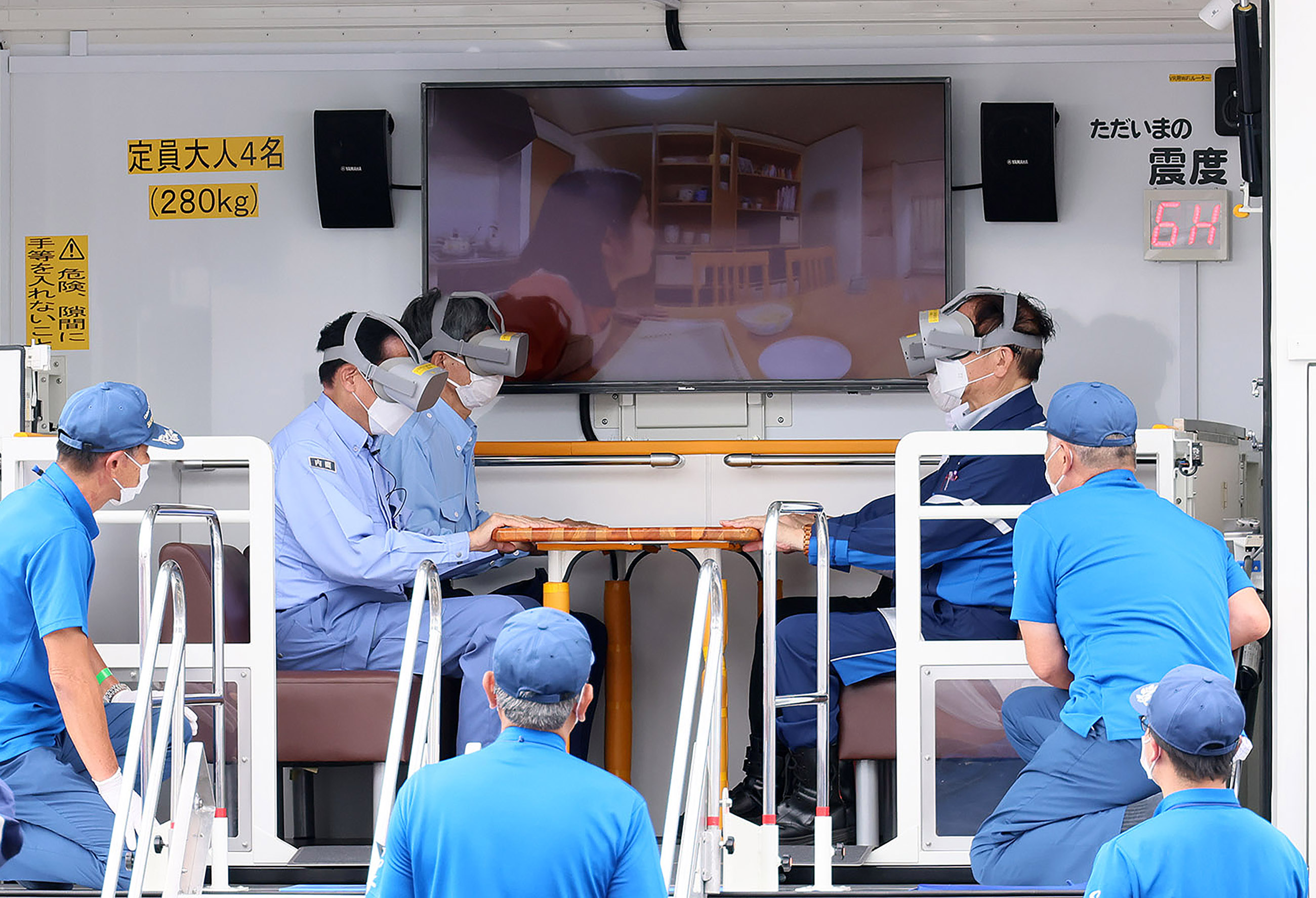 Photograph of the Prime Minister experiencing a VR earthquake simulation vehicle