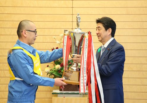 Photograph of the Prime Minister presenting a trophy