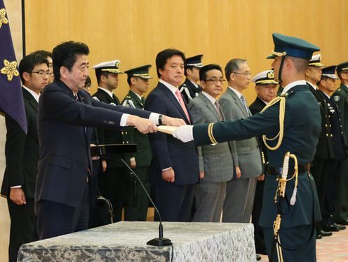 Photograph of the Prime Minister presenting a certificate of award