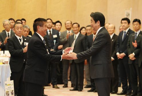 Photograph of the Prime Minister presenting a plaque