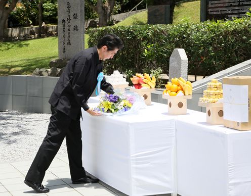 Photograph of the Prime Minister offering flowers at the Shimamori Monument