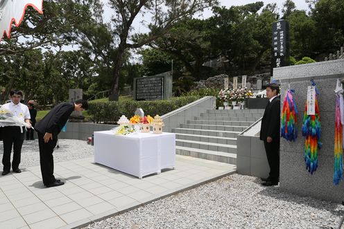 Photograph of the Prime Minister offering flowers at the Shimamori Monument