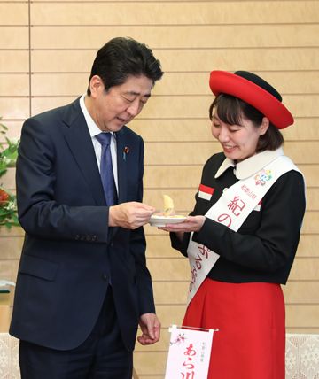 Photograph of the Prime Minister sampling the peaches