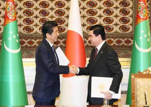 Photograph of the leaders shaking hands after the signing ceremony