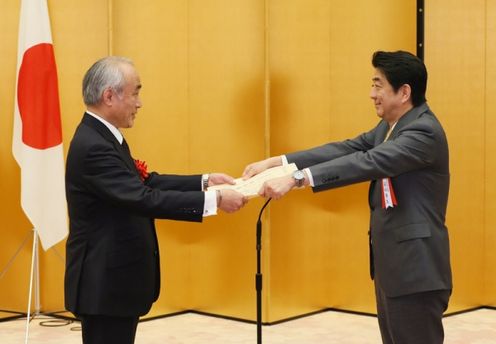 Photograph of the Prime Minister presenting a certificate of award