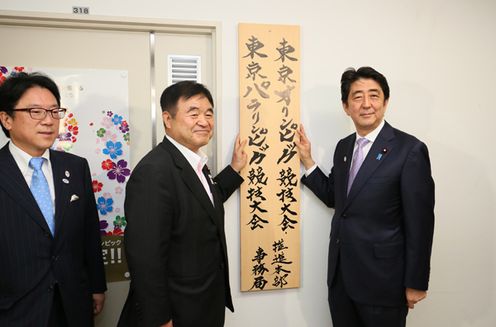 Photograph of the Prime Minister raising a signboard