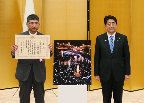 Photograph of the Prime Minister taking a commemorative photograph with a contest winner