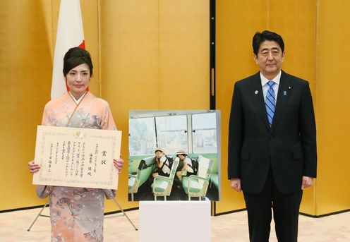 Photograph of the Prime Minister taking a commemorative photograph with a contest winner
