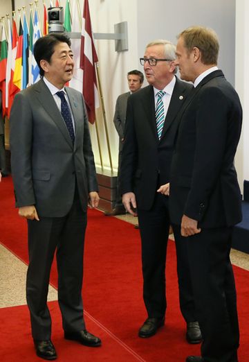 Photograph of Prime Minister Abe receiving a welcome from the President of the European Council and the President of the European Commission