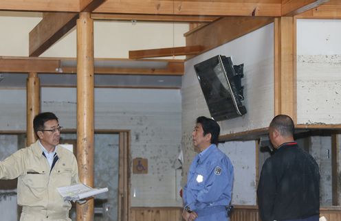 Photograph of the Prime Minister observing the state of damage at a group home (1)