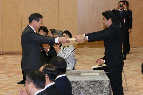 Photograph of the Prime Minister presenting a certificate of award