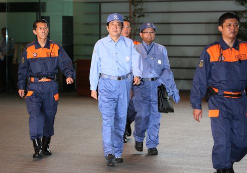 Photograph of the Prime Minister leaving the Prime Minister's Office in disaster prevention gear