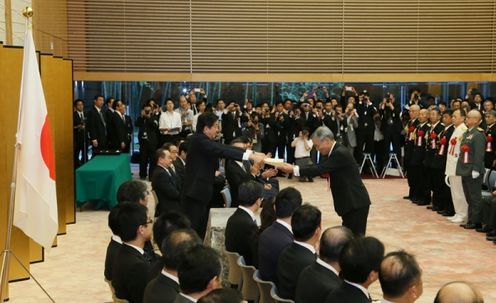 Photograph of the Prime Minister presenting a certificate of award