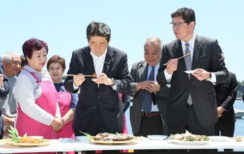Photograph of the Prime Minister tasting food at Onahama Fish Market