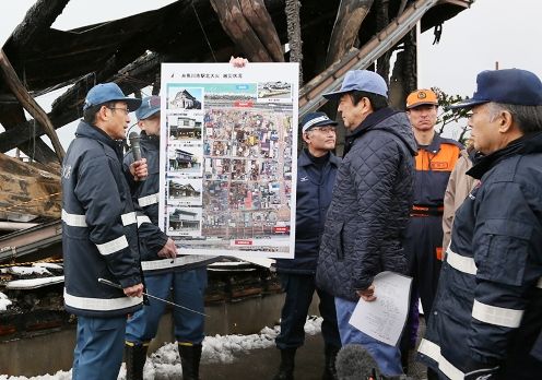 Photograph of the Prime Minister receiving an explanation at the area affected by the fire