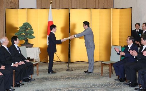 Photograph of the Prime Minister presenting a certificate of award