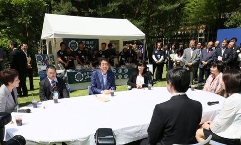 Photograph of the Prime Minister conversing with participants