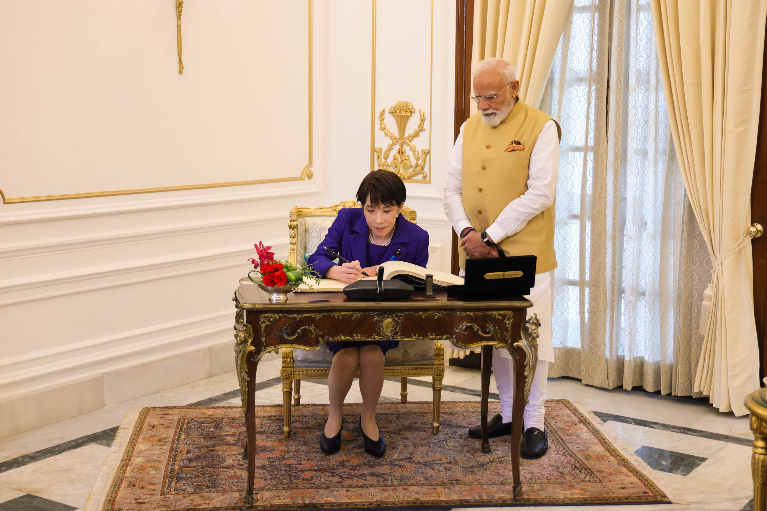 Prime Minister TAKAICHI signing the guestbook (1)