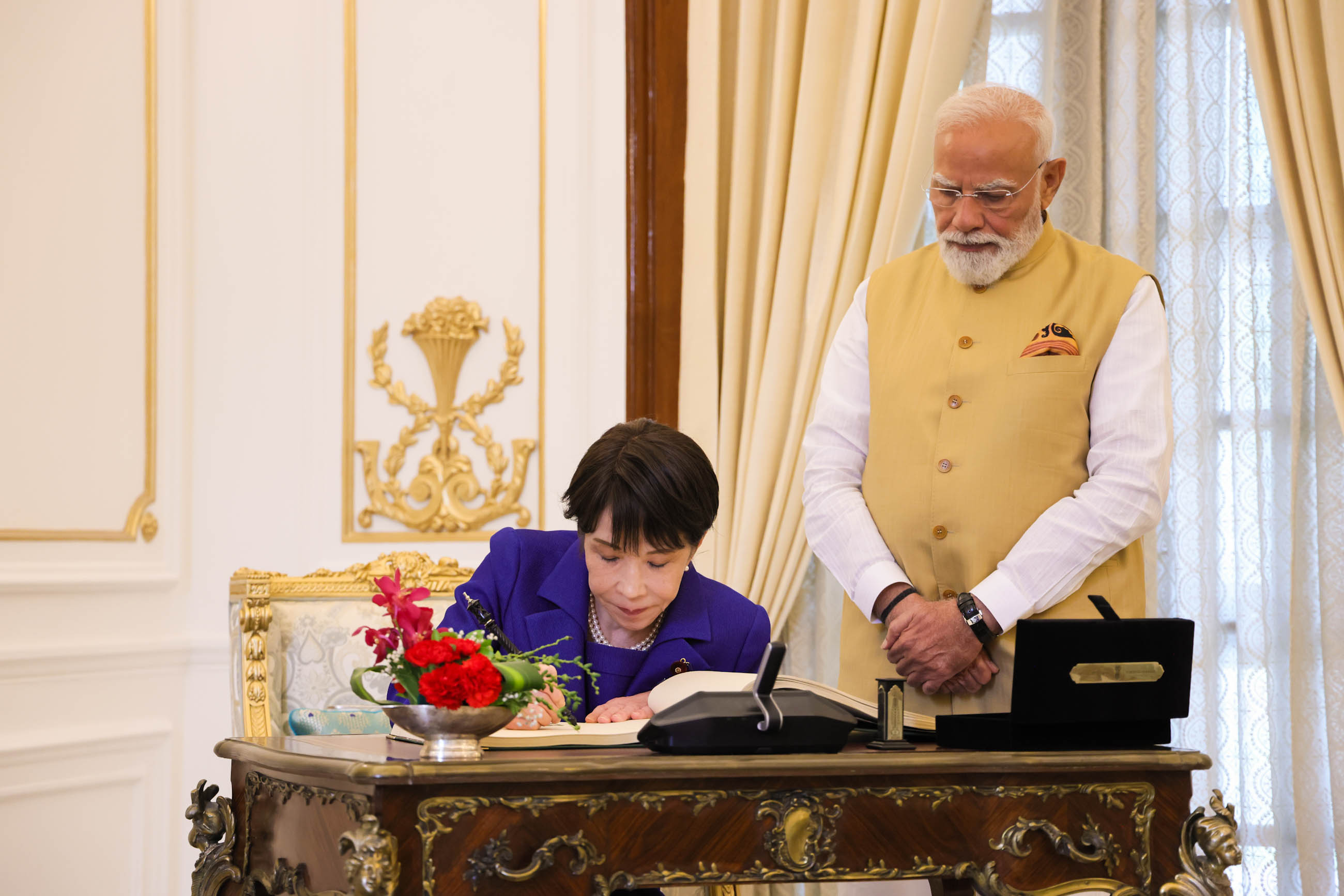 Prime Minister TAKAICHI signing the guestbook (2)