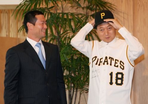 Photograph of Mr. Kuwata presenting Prime Minister Hatoyama with a cap and uniform