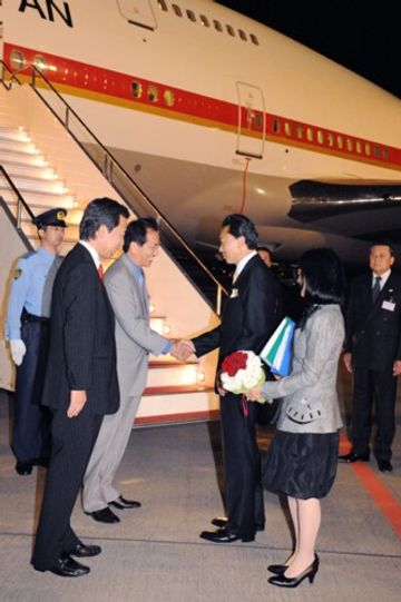 Photograph of Prime Minister and Mrs. Hatoyama being seen off by Deputy Prime Minister Kan and Chief Cabinet Secretary Hirano