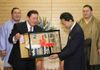 Photograph of Chairman Musashigawa presenting Prime Minister Hatoyama with miniatures of Yokozuna ropes