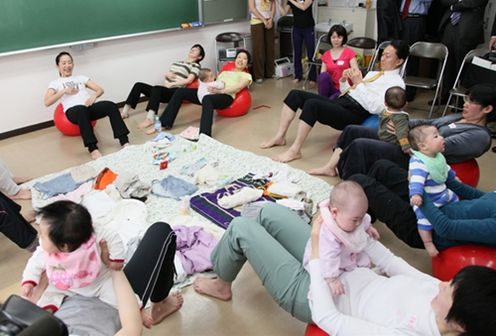 Photograph of the Prime Minister developing his abdominal muscles with postpartum mothers