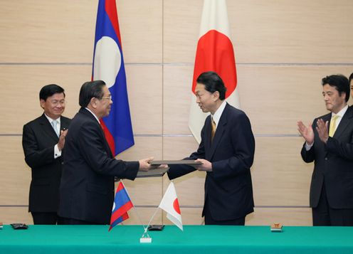 Photograph of Prime Minister Hatoyama and President Choummaly exchanging a signed document