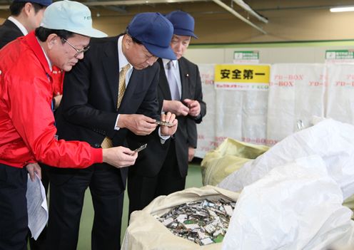 Photograph of the Prime Minister observing a recycling facility for home appliances, PCs, and mobile phones