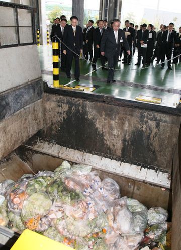 Photograph of the Prime Minister observing a recycling facility for food waste