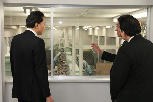 Photograph of the Prime Minister observing a recycling facility for construction waste