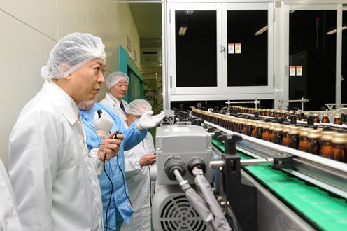 Photograph of the Prime Minister observing a pharmaceutical plant