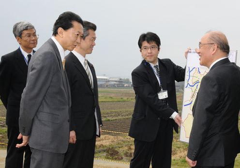 Photograph of the Prime Minister observing a road construction site