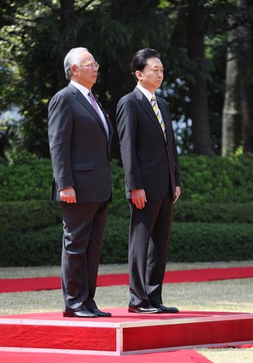 Photograph of the two leaders receiving the salute of a guard of honor