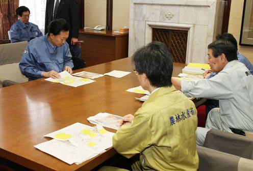 Photograph of the Prime Minister hearing an explanation from Senior Vice-Minister of the Ministry of Agriculture, Forestry and Fisheries Masahiko Yamada