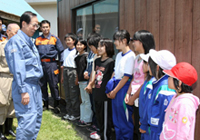 Photograph of the Prime Minister offering encouragement to the children at a site afflicted by the Iwate-Miyagi Nairiku Earthquake