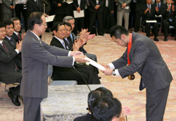 Photograph of the Prime Minister presenting an athlete with a commemorative gift