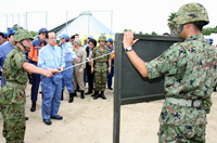 Photograph of the Prime Minister receiving an explanation on the use of tents for temporary housing