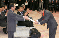 Photograph of the Prime Minister presenting an athlete with a commemorative gift